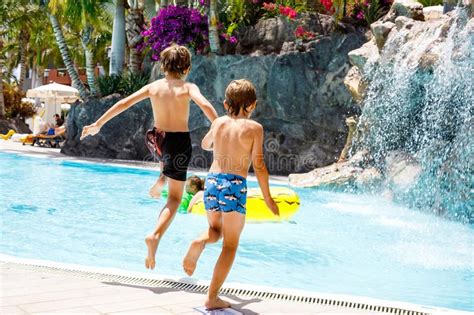 Deux Gar Ons Heureux De Petits Enfants Sautant Dans La Piscine Et Ayant