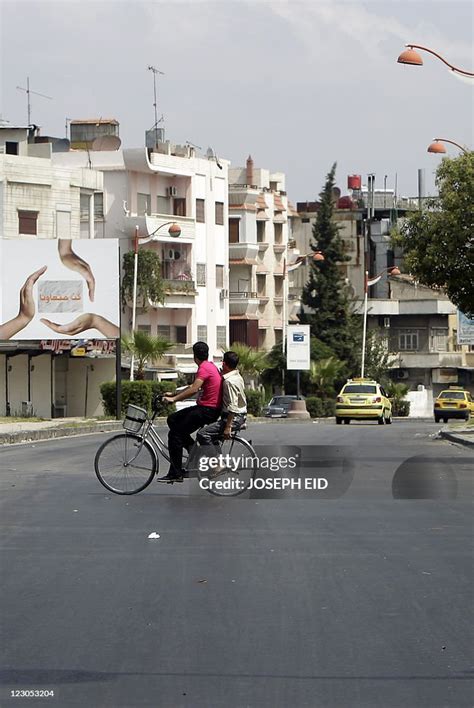 Two Syrian Youths Ride Their Bike On An Empty Street In The News