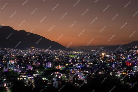 Premium Photo | A city at night with a mountain in the background