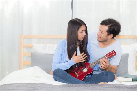 Young Asian Couple Playing Ukulele Relaxing With Happiness And Joyful