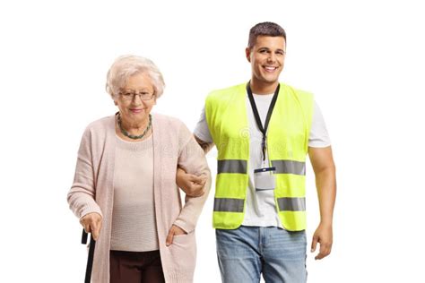 Joven Trabajador De La Comunidad Masculina Ayudando A Una Anciana Foto