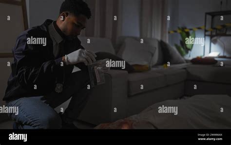 African American Detective Analyzes Evidence In A Dimly Lit Crime Scene