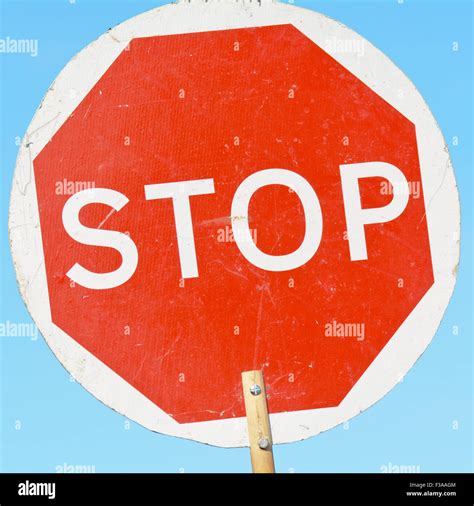 Stop Sign On Wooden Stick Held By Road Construction Workers To