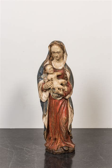 Een Polychrome En Vergulde Notelaren Sculptuur Van Een Madonna Met Kind