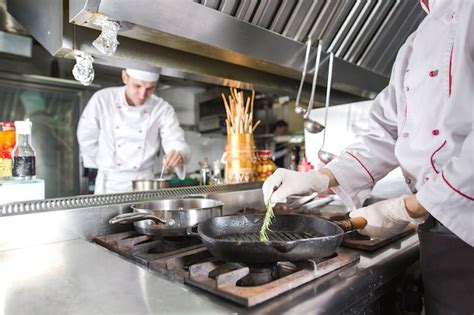 Chef En La Cocina Del Restaurante En La Estufa Con Pan Cocina Foto