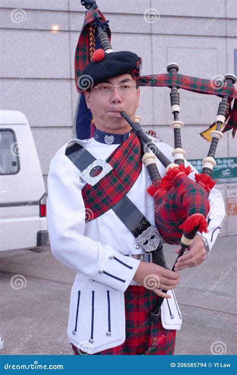 Scottish Bagpiper Dressed In Traditional Red And Black Tartan Dress Stand Editorial Stock Image