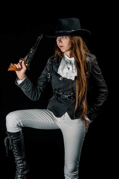 Premium Photo Cowgirl Holding Gun Against Black Background