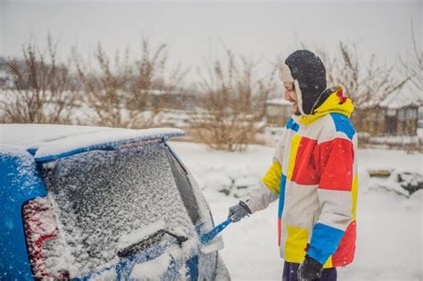 Premium Photo Removing Snow From Car With A Brush