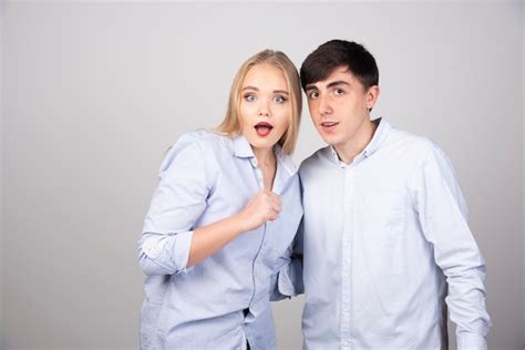 Retrato De Una Joven Pareja De Pie Juntos En La Pared Gris Foto Gratis