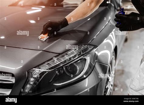 Car Detailing And Polishing Concept With Male Worker Polishing Gray