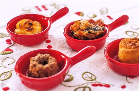 Four Red Bowls Filled With Different Types Of Desserts On A Tablecloth