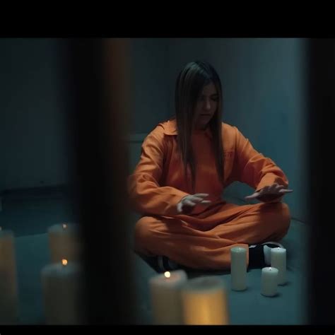 A Woman Sitting On The Floor With Candles Around Her