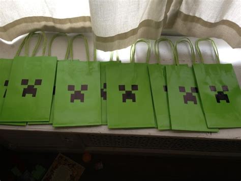 Green Paper Bags Are Lined Up In The Shape Of Minecraft Creeper Faces On Them