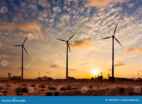 Sihouettes De Las Turbinas Del Generador De Viento En Puesta Del Sol Imagen De Archivo Imagen