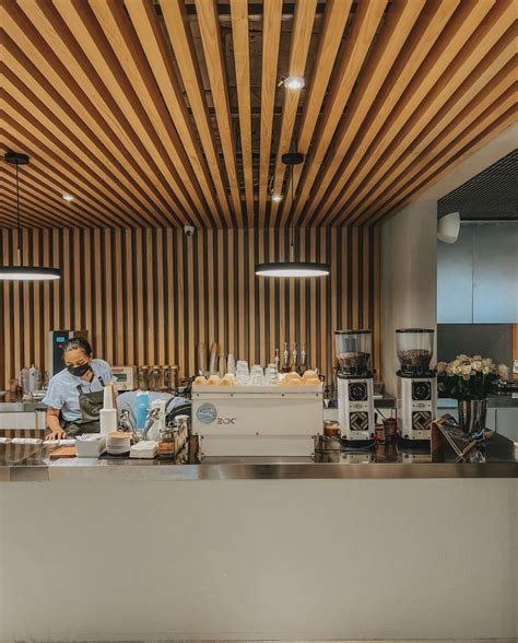 A Man Standing In Front Of A Counter With Food On It Next To A Wooden