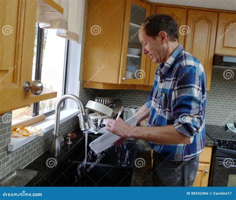 Homem Que Faz O Trabalho Da Limpeza Na Cozinha Foto De Stock Imagem