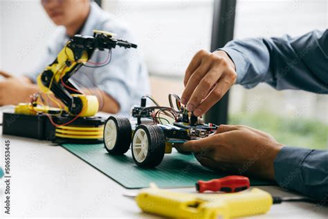 Asian teenager doing robot project in science classroom. technology of ...