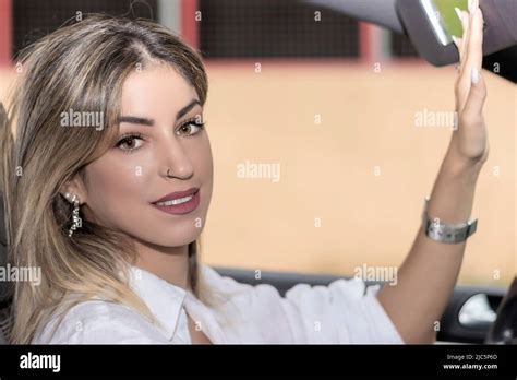 Woman Looking At Herself In The Car Mirror Stock Photo Alamy