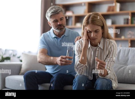 Worrying Mature Caucasian Husband Calms Wife Suffering From Headache