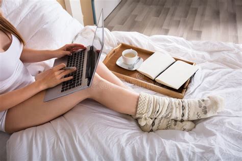 Mujer Que Se Sienta En La Cama Que Trabaja En El Ordenador Port Til