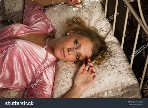 Sexual Blonde Lying On The Bed In A Boudoir Stock Photo