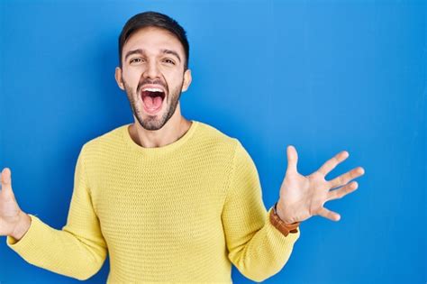 Free Photo Hispanic Man Standing Over Blue Background Celebrating