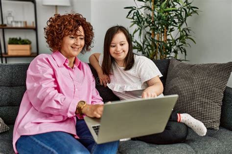 Mature Mother And Down Syndrome Daughter Using Computer Laptop At Home