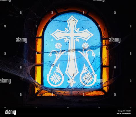 Giant Cobwebs Around A Cross Design On A Stained Glass Window Inside An