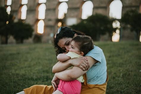 Premium Photo Mother Embracing Daughter On Field During Sunset