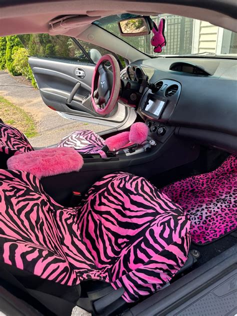 the interior of a car with pink and black zebra print cloths on it's ...