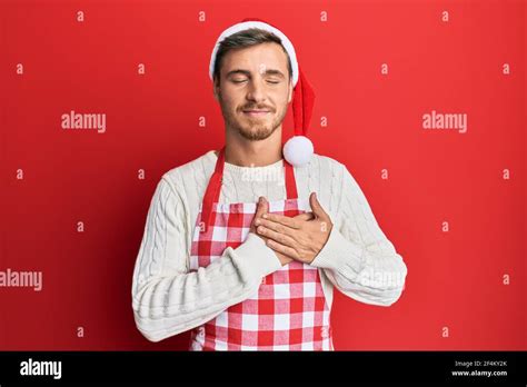 Beau caucasien portant un tablier de boulanger et chapeau de noël