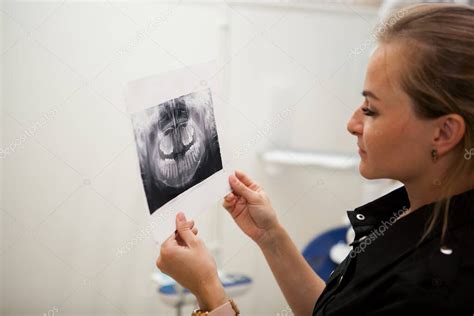 Mujer Dentista Con El Pelo Largo Y Rubio En Uniforme Negro Sostiene Una