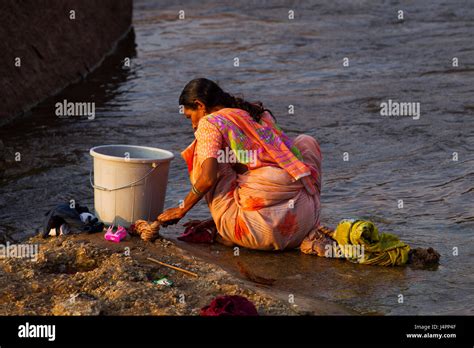 Indian Woman Washing Clothes At Tungabhadra River Hampi Karnataka