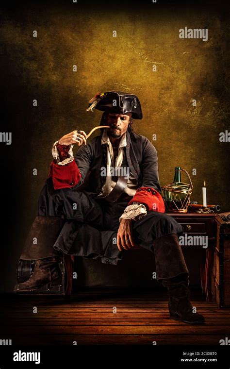 Portrait Of A Pirate Smoking A Pipe Sitting In A Tavern Stock Photo