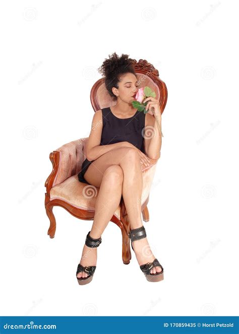 Happy Young Woman Sitting In A Old Armchair Smelling A Pink Rose Stock