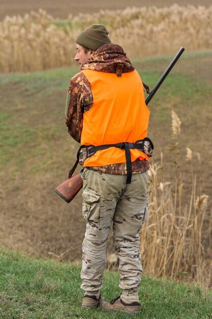 Chasseur en tenue de camouflage avec une arme à feu pendant la chasse à