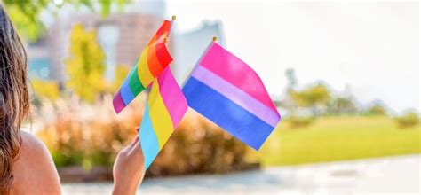 Queer de género la gente ondea banderas del arco iris del orgullo gay