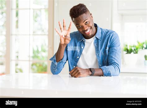 Handsome African American Man At Home Showing And Pointing Up With Fingers Number Four While