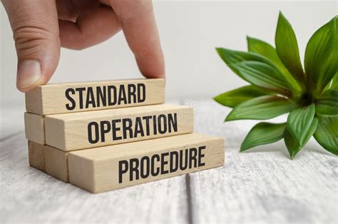 Standard Operation Procedure Words On Wooden Blocks And Hand Stock