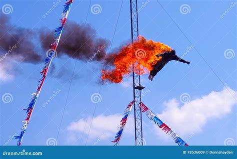 High Diver Performing A Fire Dive Off A Platform Above A Pool At A