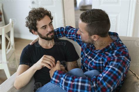 Loving Same Sex Male Gay Couple Lying On Sofa At Home And Relaxing