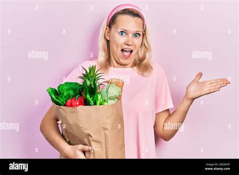 Beautiful Caucasian Blonde Woman Holding Paper Bag With Groceries