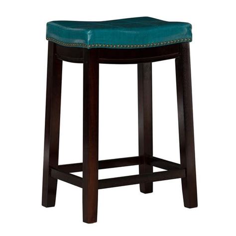 The Backless Stool Is Made From Wood And Has A Blue Leather Cushion On It