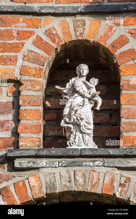 Statue Of Virgin Mary With Baby Jesus In Alcove Above Entrance Door At