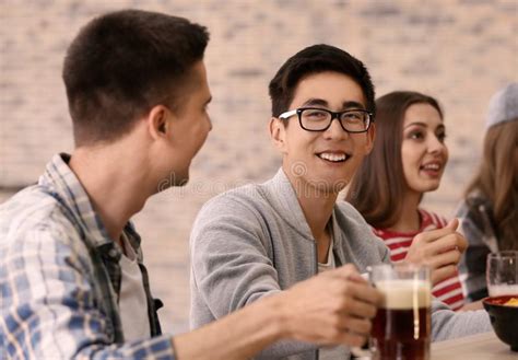 Grupo De Amigos Alegres Que Beben La Cerveza En Barra Imagen De Archivo