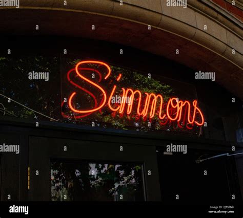 A Neon Sign Simmons At The Entrance To A Bar In West London Stock