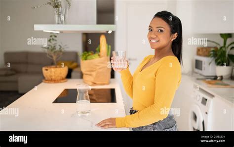 Smiling Millennial African American Lady In Casual Holding Glass Of