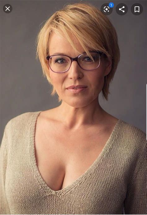 A Woman With Glasses Is Posing For The Camera