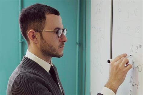 Profesor Hombre Con Gafas Escribiendo En Una Pizarra Foto Premium