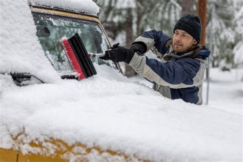 A Man Is Cleaning His Car S Windshield With A Snow Brush Stock Image